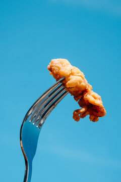 a spanish chipiron on a fork against the sky
