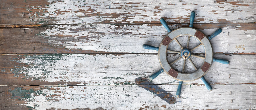 ship's steering wheel on a wooden background