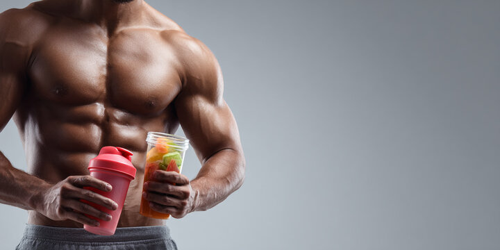 Muscular man holding protein shaker and beverage, showcasing fitness and health. Strong physique exudes confidence
