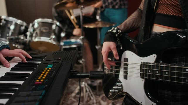 Teenagers playing synthesizer and bass guitar during music rehearsal in studio. Clip is perfect for youth lifestyle, music education, and creative hobby campaigns