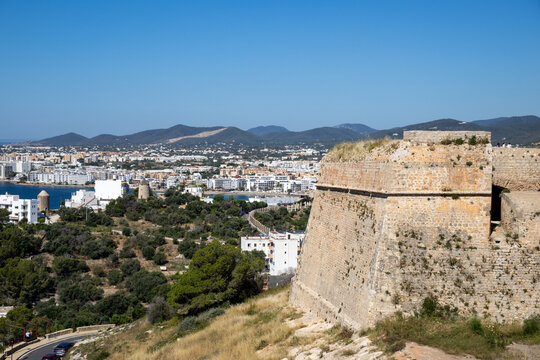 &laquo;Ibiza, Spain&raquo;; May 26 2026: Scenic panoramic view from the historic Baluarte de Sant Jordi fortress wall in Dalt Vila old town, overlooking the white houses of Ibiza city and the blue horizon 
