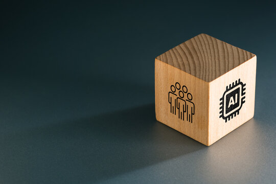 Wooden cube showing people and AI icons on different sides, symbolizing human-centered artificial intelligence, collaboration, governance, and the evolving relationship between technology and people
