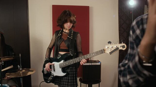 Diverse Caucasian and African American teenage girls playing musical instruments during rock band rehearsal in studio. Footage is ideal for youth lifestyle ads and music education promos
