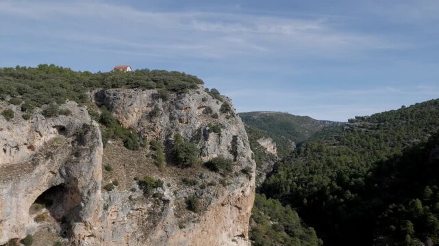 Aerial view descends cliffside to lush river valley at Ventano del Diablo lookout