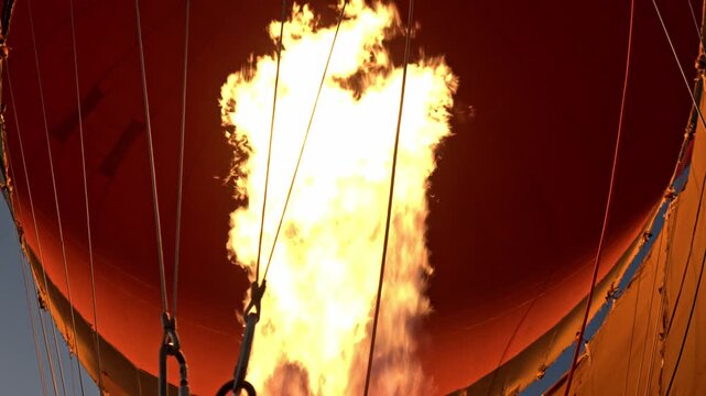 Low-angle point-of-view shot from inside the basket shows a powerful blast of fire erupting from the burner of a Balloon in The Valley of the Kings in Luxor, Egypt.