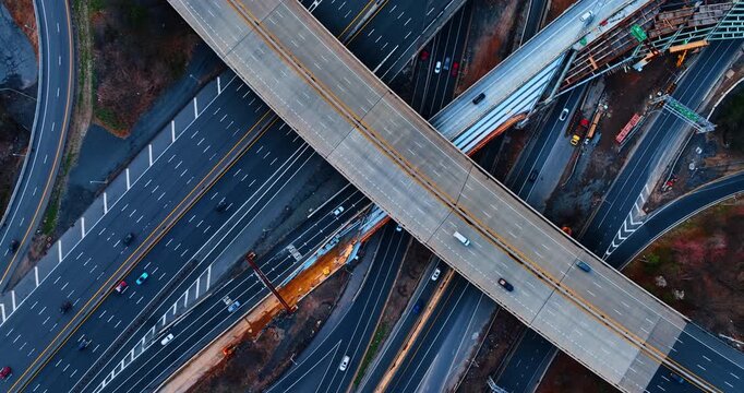 Overhead view of a highway intersection, Woodbridge, New Jersey. Top down drone shot of cars moving along multi lane concrete roads and crossing bridge overpasses.