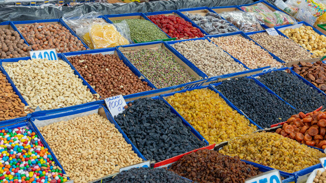 Assorted dried fruits, raisins, nuts, and sweets displayed in open bins at a traditional market stall in Osh Bazaar, Bishkek, Chuy Region, Kyrgyzstan