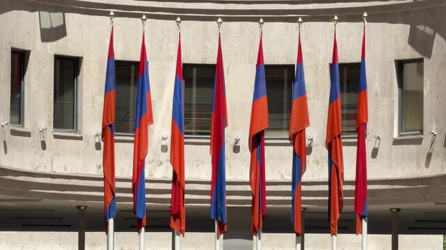 National Flag Display: A row of Armenian flags stands proudly in front of a modern building, symbolizing national pride and heritage.