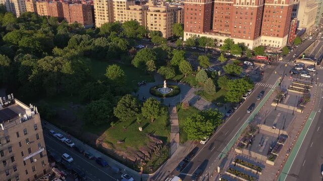 Grand Concourse in The Bronx showing historic district buildings and Joyce Kilmer Park with Lorelei Fountain during a warm sunset over New York City neighborhood