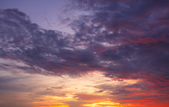 Vibrant Sunset Clouds Filling the Evening Sky,A breathtaking view of a dramatic sunset with purple, orange, and red clouds scattered across the horizon, creating a peaceful and inspiring atmosphere.