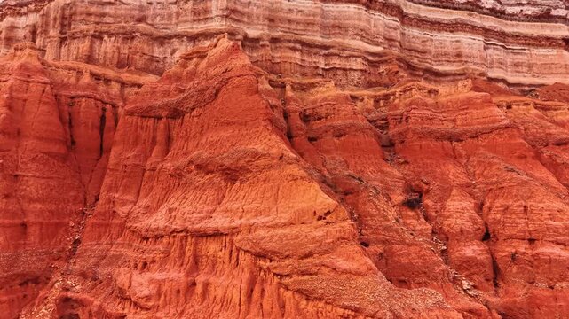 Detailed texture of eroded red clay rocks, Teruel, Aragon, Spain. Close view of weathered geological strata and natural orange sediment layers.
