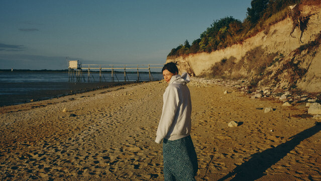young woman walking on the beach in france on a sunny day