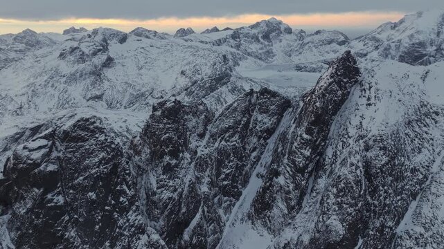 Aerial twilight view of jagged snow-covered mountain ridge