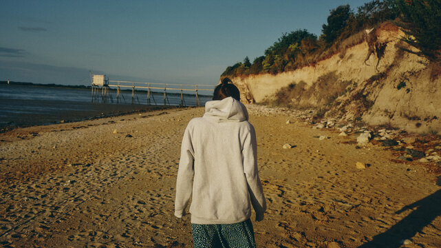 young woman walking on the beach in france on a sunny day