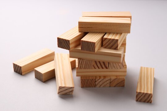 Risk and instability. Broken tower made of wooden blocks on white background, closeup