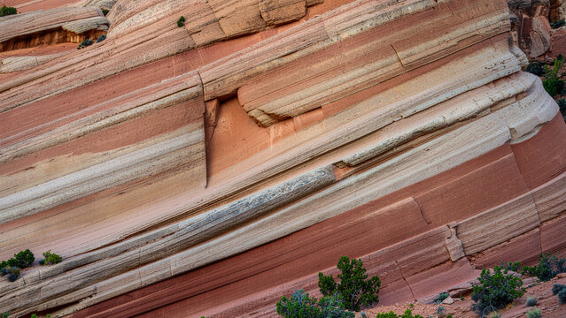 Textured red sandstone rock formation displaying layered colorful sedimentary striations