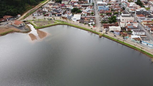 Aerial view of Capit&oacute;lio, Brazil, featuring the city sign, urban landscape, and the famous Furnas Lake surrounded by rolling hills, scenic countryside, and natural beauty.