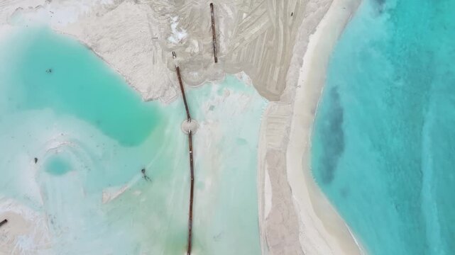 Aerial view of land reclamation works with dredging pipes and white sand tracks along the turquoise coastline of Gulhi, Kaafu Atoll, Maldives.