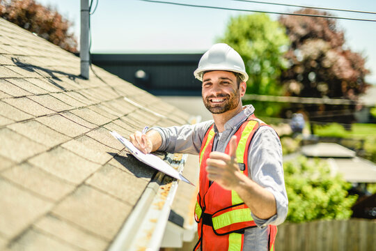 Man with a white hard hat holding a clipboard, inspect house