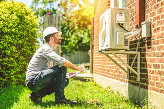 technician working on air conditioning or heat pump outdoor unit inspection or repair