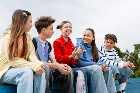Diverse teenagers sharing friendship and communication outdoors