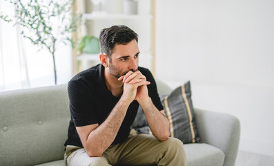 Fototapeta premium Stressed unhappy young 30s man lost in negative thoughts, having problems in personal life situation