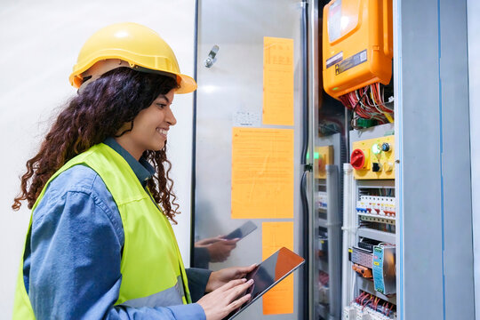 Smiling engineer holding tablet PC near server