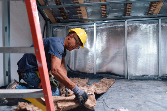Mature construction worker working on insulation at site