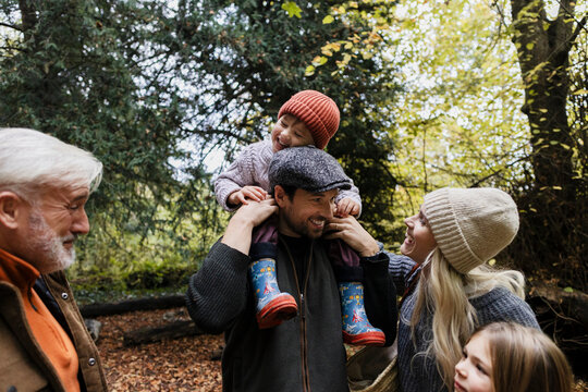 Happy multi generational family together outdoors in autumn woods