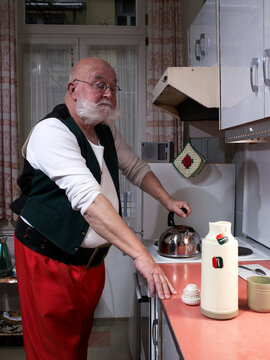 Santa Claus standing in the kitchen at night preparing hot tea