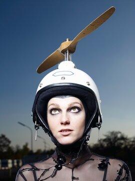 Woman wearing propeller helmet outdoors dreaming of freedom