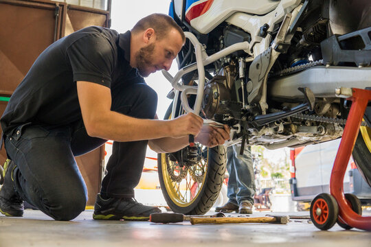 Mechanic working on motorcycle in workshop