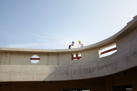 Two men on construction site discussing construction plan