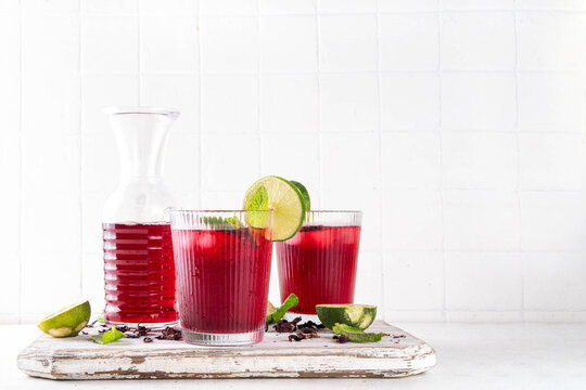 Iced Hibiscus Tea Recipe, traditional summer Agua de Jamaica. Summer cold refreshing drink - tea or juice with ice and mint, copy space