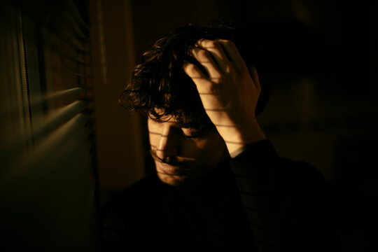 Man displaying deep mental stress and contemplation indoors
