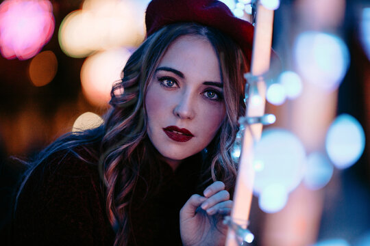 Fashion model enjoying festive city lights outdoors at night