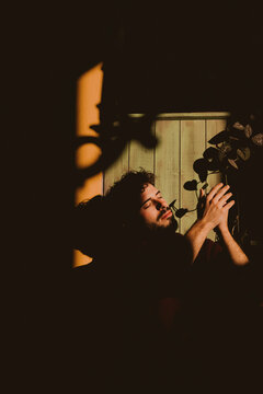 Man with closed eyes in warm dramatic sunlight