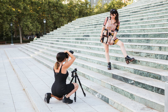 Young woman wearing patterned dress posing for a photo shoot on stairs