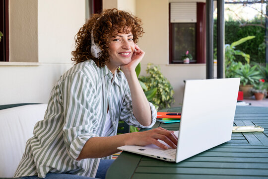 Smiling freelancer working from home on outdoor patio