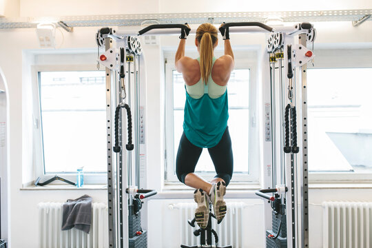 Woman doing pull-ups in gym