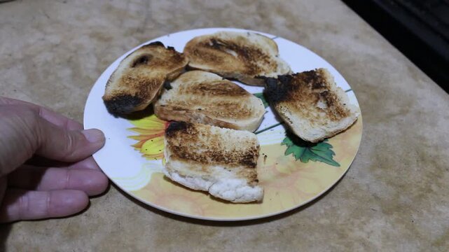 El hombre con su mano desliza el plato con las tostadas de campo recien hechas sobre la mesa de piedra,  para comer su desayuno de la ma&ntilde;ana, creando  una atm&oacute;sfera hogare&ntilde;a.