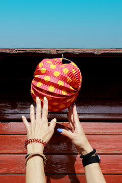 Hands reaching for a colorful paper lantern at a Spanish feria