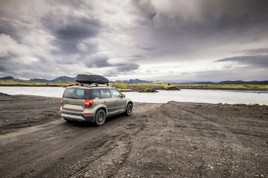 Rugged suv by a glacial river on a volcanic plain in Iceland