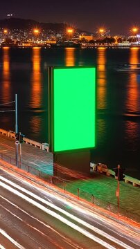 Green screen on waterfront at night with city lights advertisement mockup