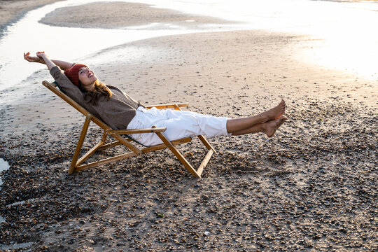 Woman stretching and relaxing in a beach chair by the sea