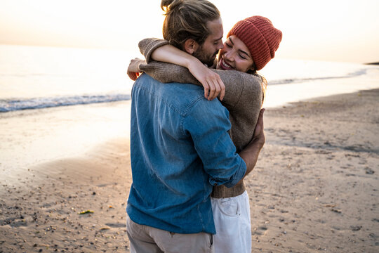 Romantic couple hugging on the beach at sunset