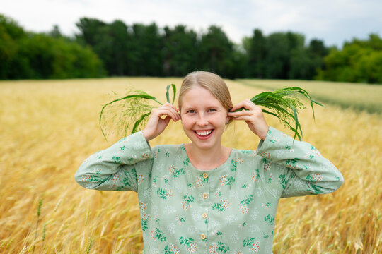 Smiling woman in a summer wheat and rye field wearing vintage clothing