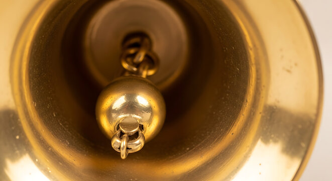Brass bell interior with coiled striker and metal clapper detailed close up photo