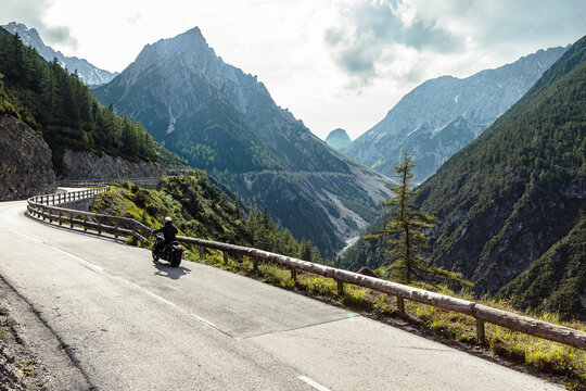 Biker riding motorcycle on road by Lechtal valley, Pfafflar, Tirol, Austria