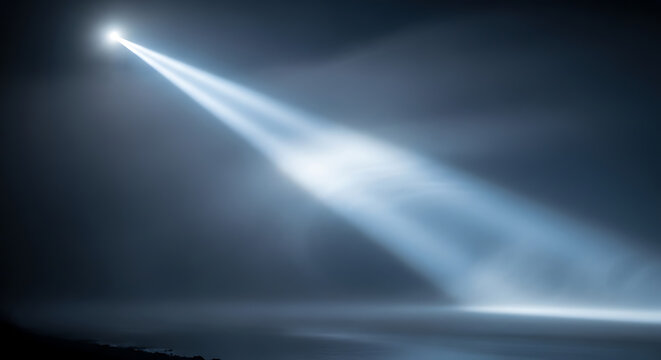 Bright searchlight beam cutting through a dark foggy night sky atmospheric lighting